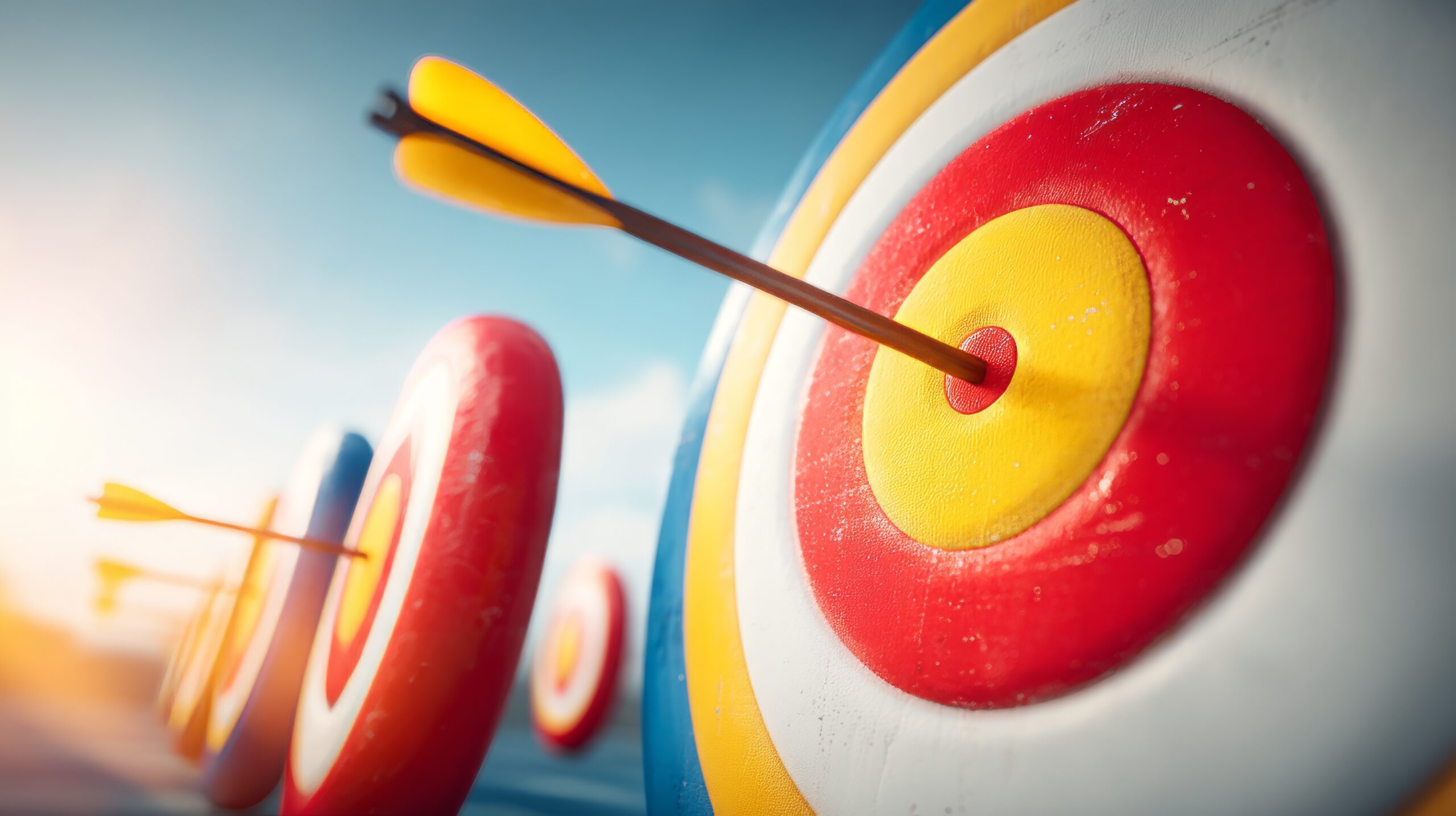This image features a close-up view of inflatable targets arranged in ascending order, with arrows striking the bullseyes, showcasing precision in archery.
